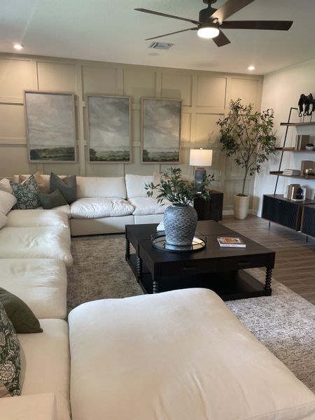 A cozy living room with plush white sofas, chic decor, and elegant artwork, creating a serene and inviting atmosphere.