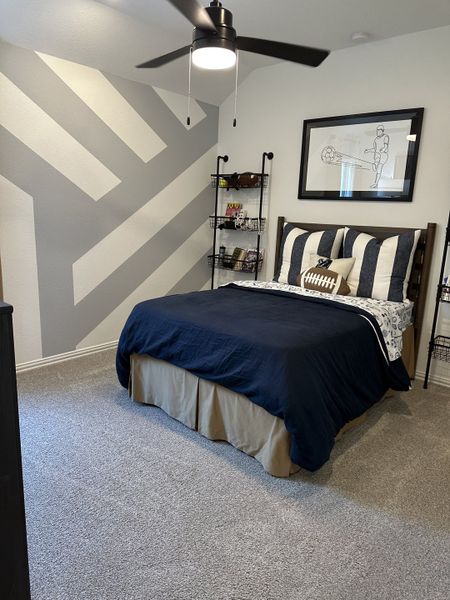 A modern bedroom with a bold geometric accent wall, cozy bedding, and sleek shelving. A modern bedroom with a bold geometric accent wall, cozy bedding, and sleek shelving.