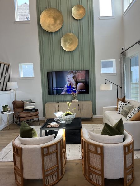 A stylish living room with modern decor, featuring a green accent wall, unique wall art, and a cozy seating area. A stylish living room with modern decor, featuring a green accent wall, unique wall art, and a cozy seating area.