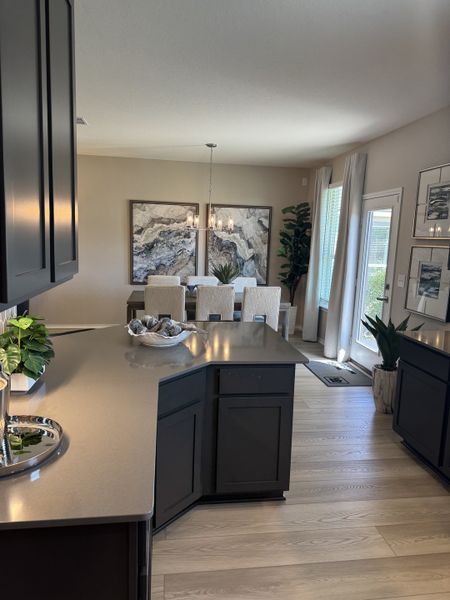 A modern dining area with elegant artwork, plush seating, and large windows, seamlessly connected to a stylish kitchen. A modern dining area with elegant artwork, plush seating, and large windows, seamlessly connected to a stylish kitchen.