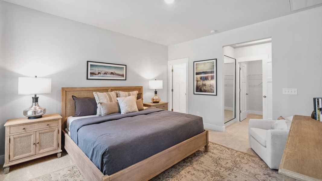 Primary bedroom with en suite bathroom, elevated ceilings, and hardwood flooring at Aspen Ridge by DRB Homes in Lyman, SC Primary bedroom with en suite bathroom, elevated ceilings, and hardwood flooring at Aspen Ridge by DRB Homes in Lyman, SC