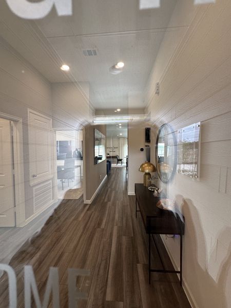 A modern hallway featuring wood flooring, sleek decor, and ambient lighting.