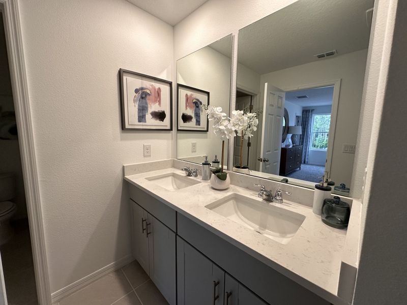 A sleek bathroom with dual sinks, elegant fixtures, and modern artwork, offering a bright, inviting atmosphere. A sleek bathroom with dual sinks, elegant fixtures, and modern artwork, offering a bright, inviting atmosphere.