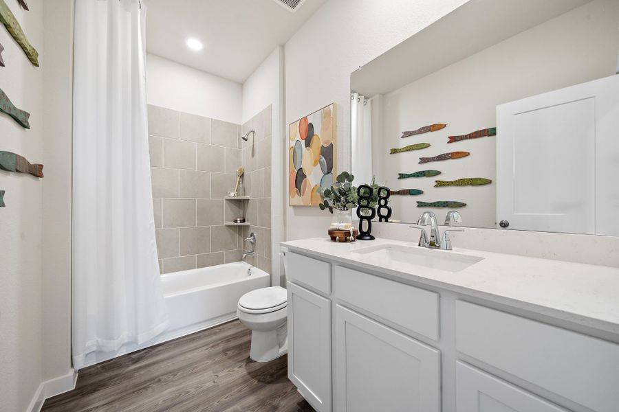 A bathroom with a tub sink and toilet.