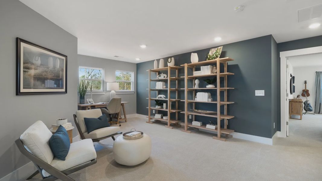 Loft space in Anderson, SC with accent wall, large windows, and plush carpet at Village at Midway by DRB Homes Loft space in Anderson, SC with accent wall, large windows, and plush carpet at Village at Midway by DRB Homes