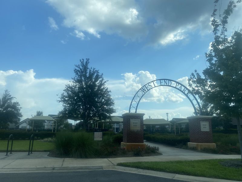 A scenic entrance to West End Park in West End at Town Center by ICI Homes, featuring lush greenery in Ponte Vedra, FL.