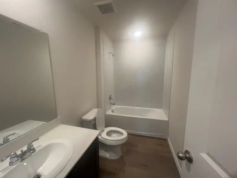A modern bathroom featuring a sleek vanity, spacious mirror, and a bathtub with elegant lighting. A modern bathroom featuring a sleek vanity, spacious mirror, and a bathtub with elegant lighting.