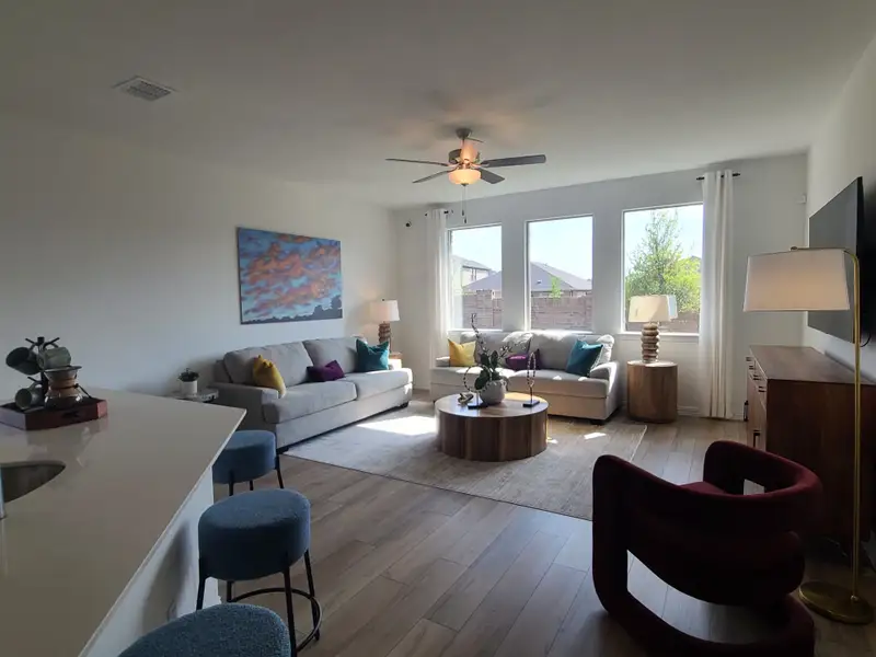 A contemporary living room with neutral tones, colorful pillows, and modern furniture. Bright and inviting with ample natural light. A contemporary living room with neutral tones, colorful pillows, and modern furniture. Bright and inviting with ample natural light.