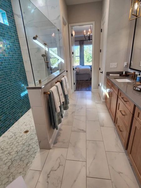 A spa-like shower with teal mosaic tiles, glass enclosure, and marble flooring, creating a sophisticated retreat. A spa-like shower with teal mosaic tiles, glass enclosure, and marble flooring, creating a sophisticated retreat.