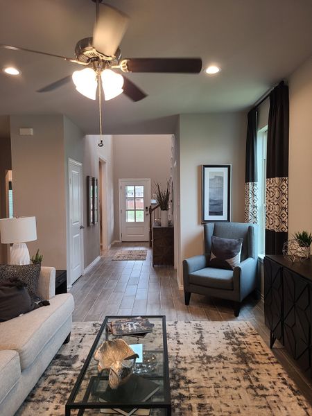 A cozy living space featuring a plush sofa, modern lighting, and sleek tile flooring.