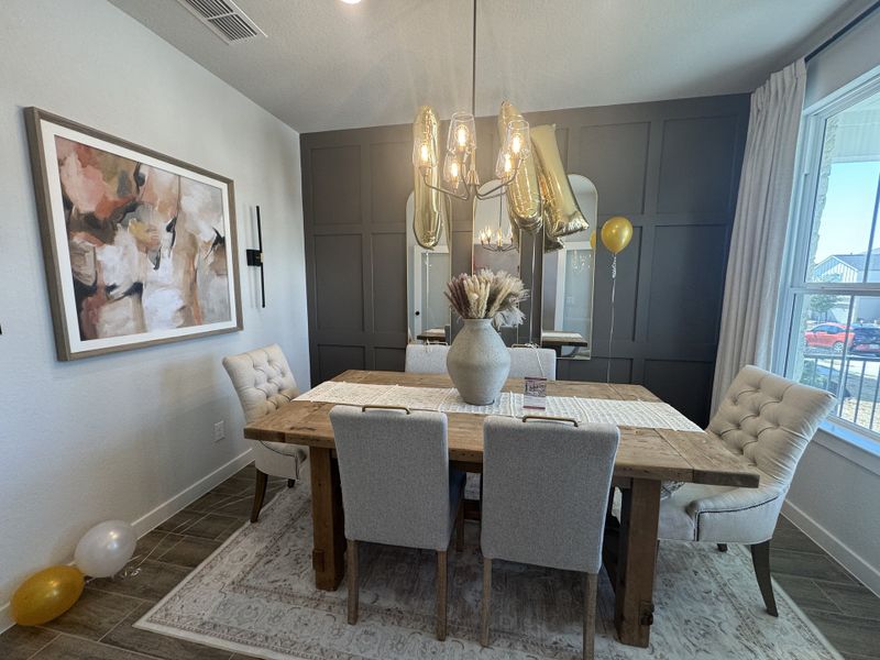 A cozy dining room featuring a rustic wooden table, elegant chairs, modern lighting, and abstract art. A cozy dining room featuring a rustic wooden table, elegant chairs, modern lighting, and abstract art.