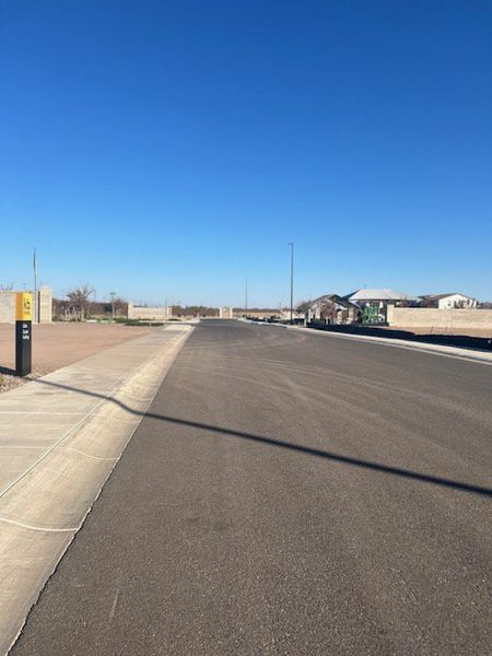A developing street view with clear skies in Cordillera by KB Home (Gilbert, AZ).