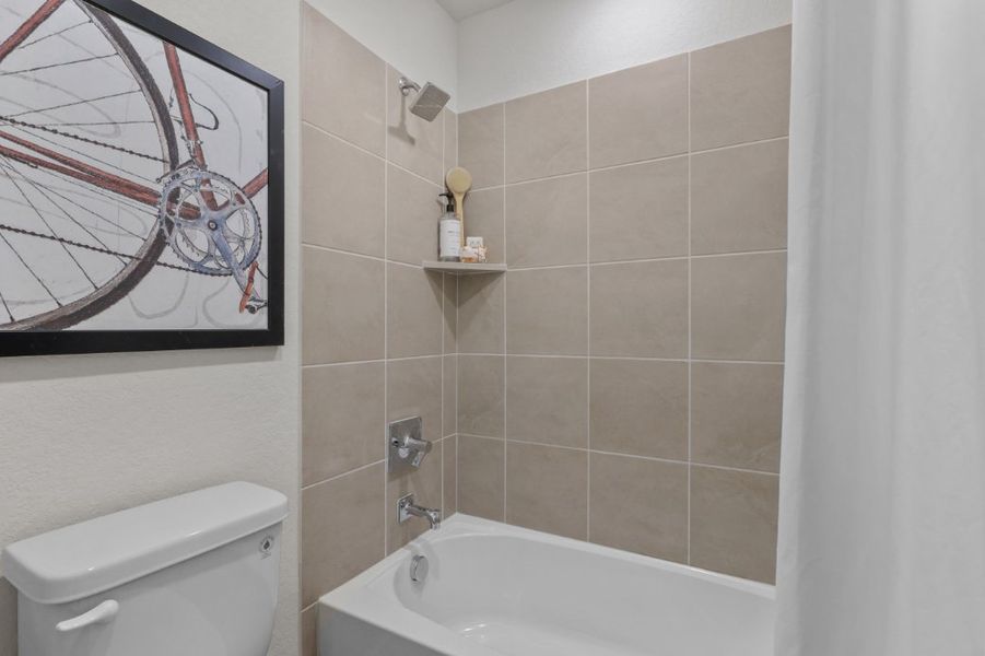 A bathroom with a tub and a mirror.