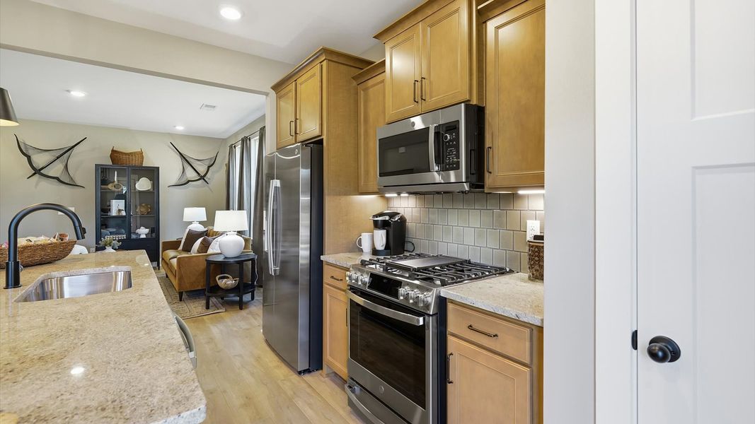 Tasteful kitchen with oversized island and stylish pendant lighting—crafted to high standards by DRB Homes