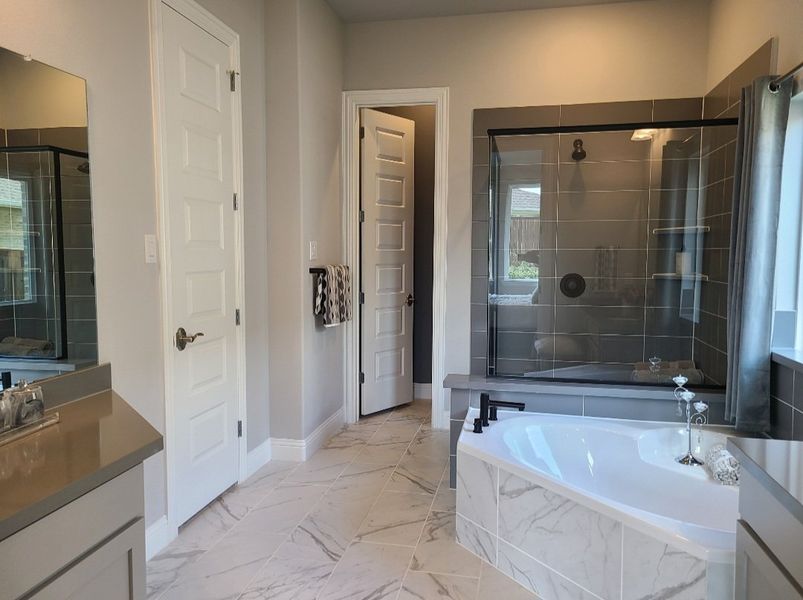 A sleek bathroom with marble floors, a glass-enclosed shower, and a luxurious soaking tub. A sleek bathroom with marble floors, a glass-enclosed shower, and a luxurious soaking tub.
