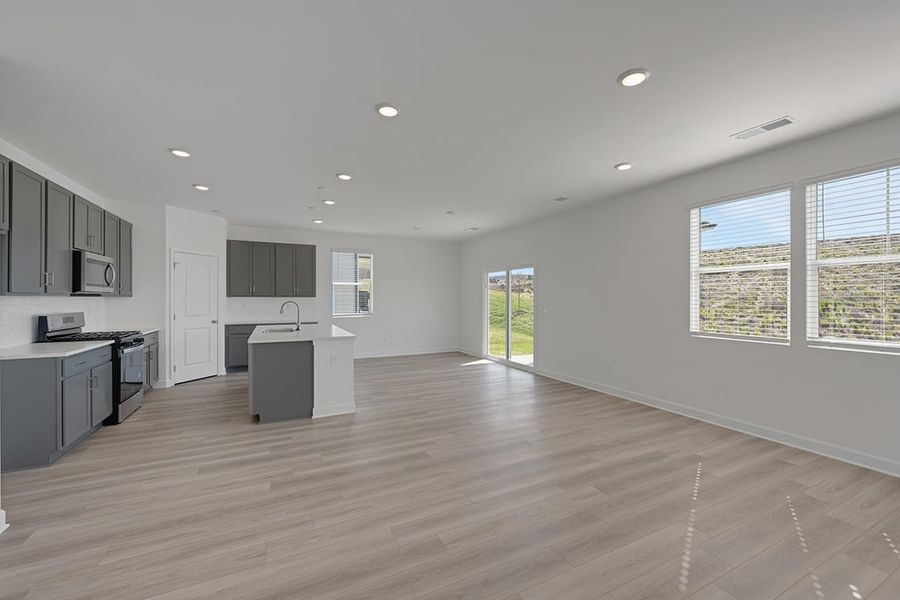 A large kitchen with black cabinets. A large kitchen with black cabinets.