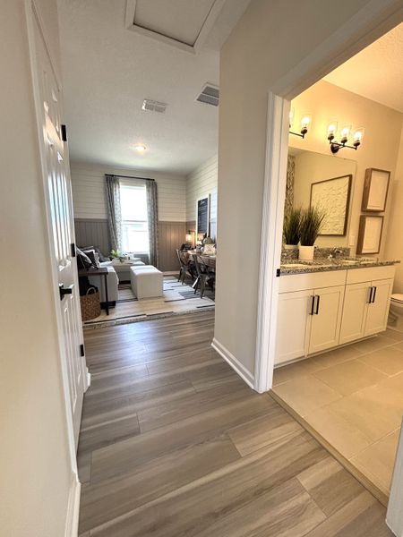 A cozy hallway leading to a bright living area with wood and tile flooring, and stylish decor.