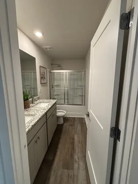 A modern bathroom with granite countertops, sleek cabinetry, and a glass-enclosed shower. A modern bathroom with granite countertops, sleek cabinetry, and a glass-enclosed shower.