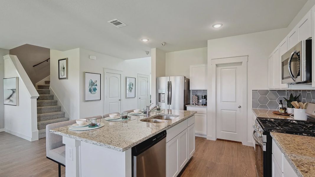 Luxurious kitchen in Patriot Estates features granite countertops, sleek island, hexagonal backsplash, and stainless steel appliances. Luxurious kitchen in Patriot Estates features granite countertops, sleek island, hexagonal backsplash, and stainless steel appliances.