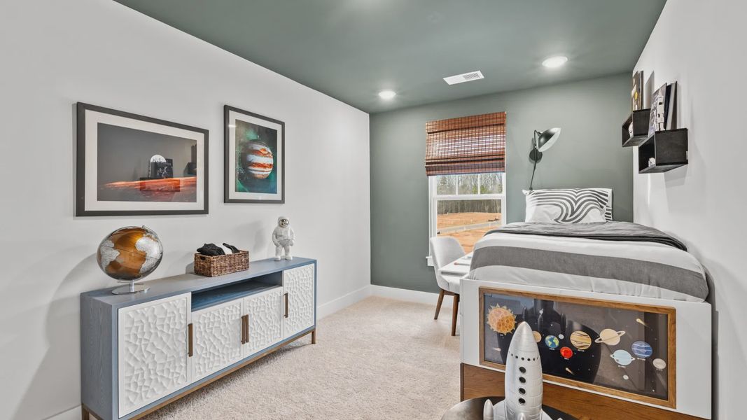 Elevated secondary bedroom with accent wall and ceiling, carpeted flooring, and large window at Aspen Ridge in Lyman, SC Elevated secondary bedroom with accent wall and ceiling, carpeted flooring, and large window at Aspen Ridge in Lyman, SC