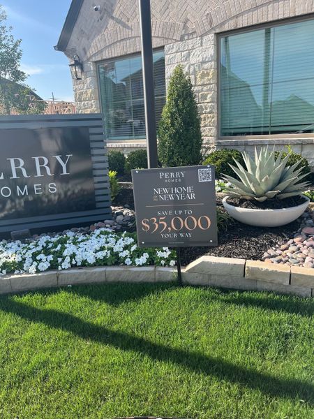 Elegant stone exterior with lush landscaping and signage in Avondale 45' by Perry Homes, Fate, TX.