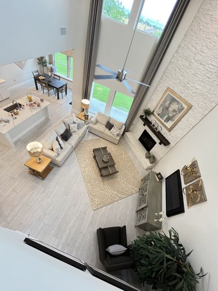 A spacious, elegant living room with high ceilings, modern furnishings, and large windows offering plenty of natural light.