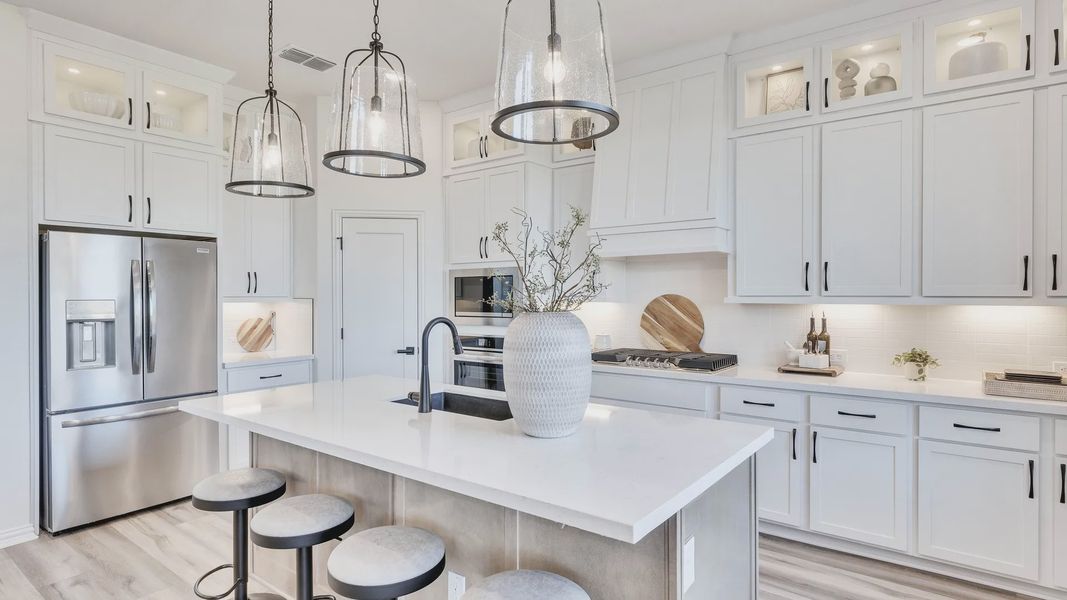 Revel in high-end finishes, marble countertops, chic pendant lighting in Briarwood's refined kitchen.