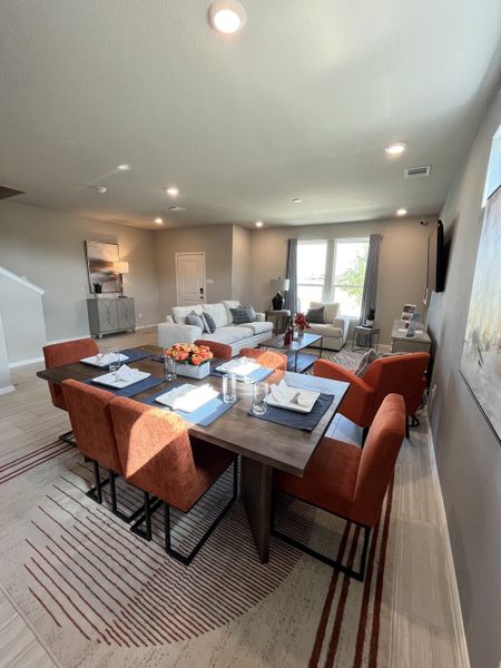 A contemporary living and dining space with plush chairs, sleek table, and ample natural light. A contemporary living and dining space with plush chairs, sleek table, and ample natural light.