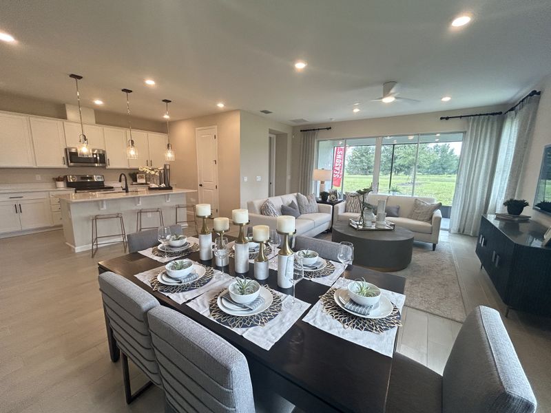 An elegant open-concept living space with a sleek kitchen, cozy dining area, and bright lounge, all tastefully decorated. An elegant open-concept living space with a sleek kitchen, cozy dining area, and bright lounge, all tastefully decorated.