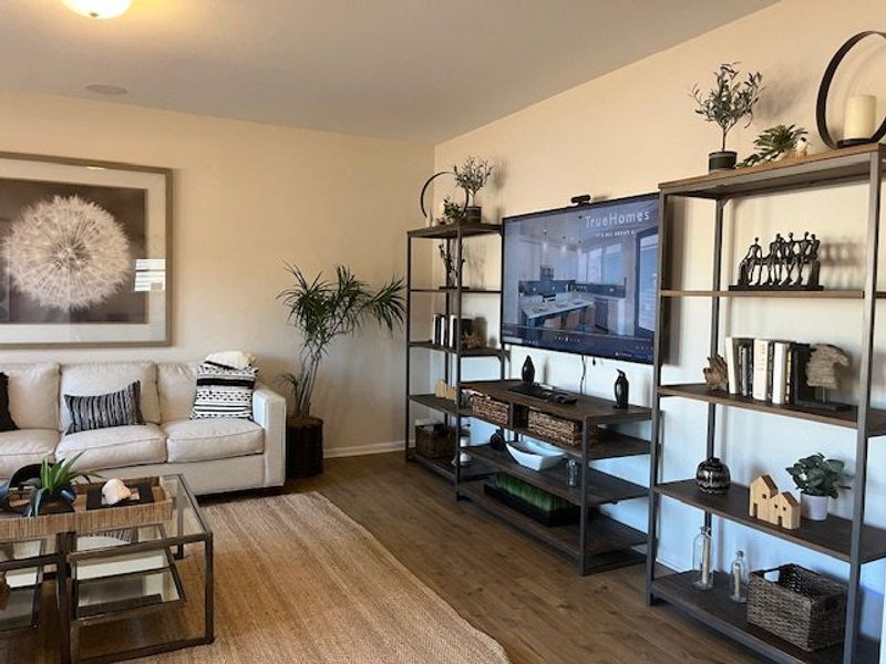 A cozy living room with neutral decor, sleek shelving, and a comfortable sofa set on a warm wooden floor.