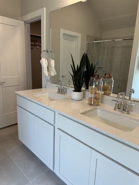 A sleek bathroom featuring a double vanity, large mirror, and modern fixtures, complemented by neutral tones and elegant decor. A sleek bathroom featuring a double vanity, large mirror, and modern fixtures, complemented by neutral tones and elegant decor.