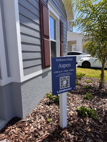 A charming home with gray siding and red shutters in Wellness Ridge: Manor Collection by Lennar (Clermont, FL).