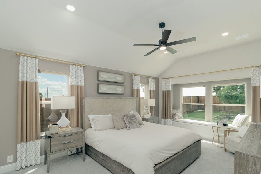 Master bedroom with vaulted ceiling, ceiling fan, large windows, and neutral gray and tan decor Master bedroom with vaulted ceiling, ceiling fan, large windows, and neutral gray and tan decor