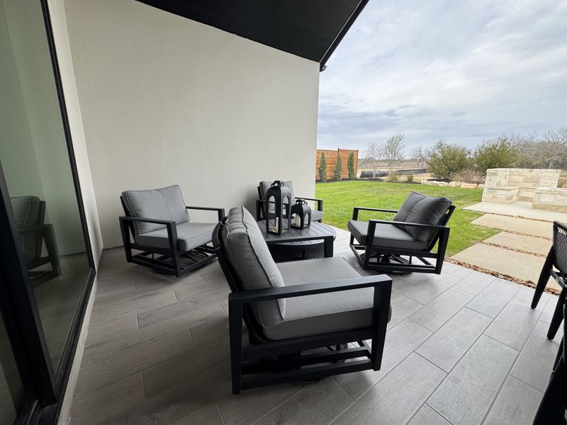 Modern patio with sleek furnishings, soft grey cushions, and a landscaped view for a serene outdoor retreat. Modern patio with sleek furnishings, soft grey cushions, and a landscaped view for a serene outdoor retreat.