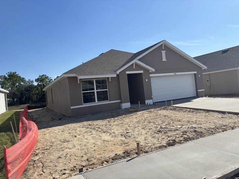 A modern gray home with a two-car garage and open yard in Autumn Glen by D.R. Horton (Belleview, FL).
