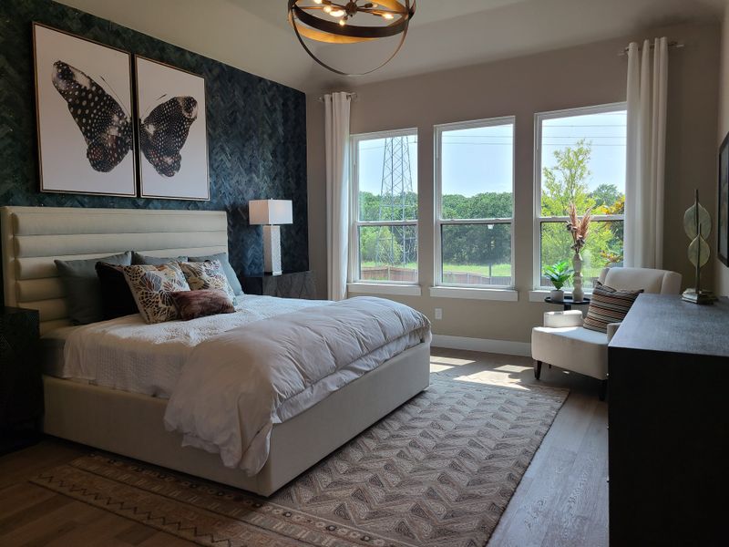 A serene bedroom with a plush bed, chic décor, and large windows offering a view of the greenery outside. A serene bedroom with a plush bed, chic décor, and large windows offering a view of the greenery outside.