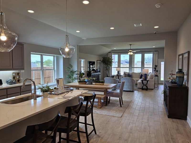 An open-concept living area with wood floors, a modern kitchen island, and stylish lighting creates a cozy atmosphere. An open-concept living area with wood floors, a modern kitchen island, and stylish lighting creates a cozy atmosphere.