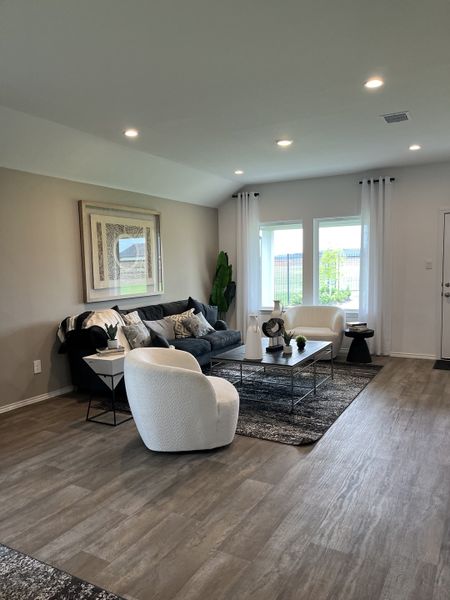 A cozy living room with modern seating, elegant decor, and large windows letting in natural light. A cozy living room with modern seating, elegant decor, and large windows letting in natural light.