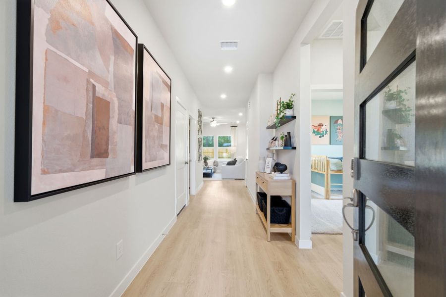 A hallway with a wood floor and a wood floor with a bookcase and a bookcase.