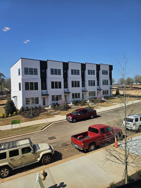 Modern white townhomes with manicured lawns in The Gathering – Alpharetta by Brock Built (Alpharetta, GA).