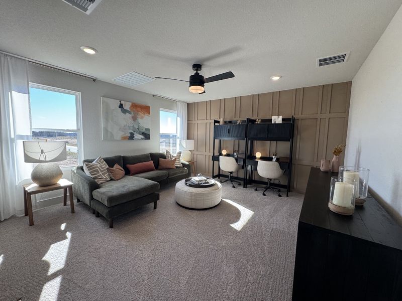 A cozy living space with a sectional sofa, stylish desk area, and modern decor.