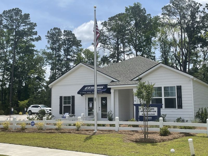 A charming white home with a welcoming entrance and landscaped yard in Pineview North by D.R. Horton (Summerville, SC).