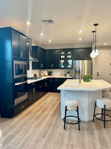 A modern kitchen with dark cabinets, a sleek island, and stylish lighting.