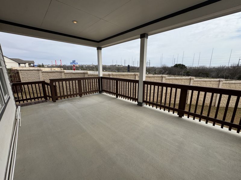 A spacious covered patio with wooden railings, perfect for outdoor relaxation.