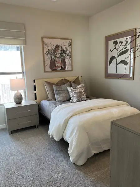 A cozy bedroom featuring soft neutral tones, elegant artwork, and plush bedding for a relaxing ambiance.