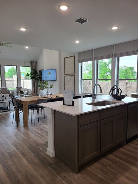 An open-concept kitchen and dining area with wooden floors, ample natural light, and modern finishes. An open-concept kitchen and dining area with wooden floors, ample natural light, and modern finishes.
