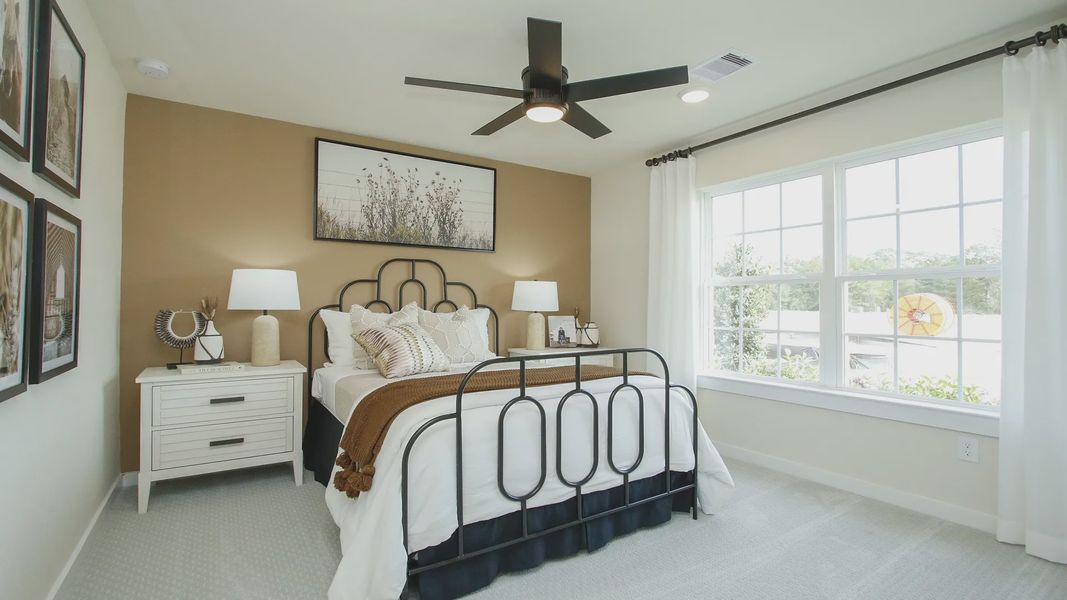 Bask in natural light from expansive windows in this refined Pinehurst bedroom with chic finishes.