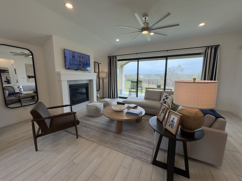 A contemporary living room with a cozy fireplace, sleek furniture, and large windows overlooking a scenic view.