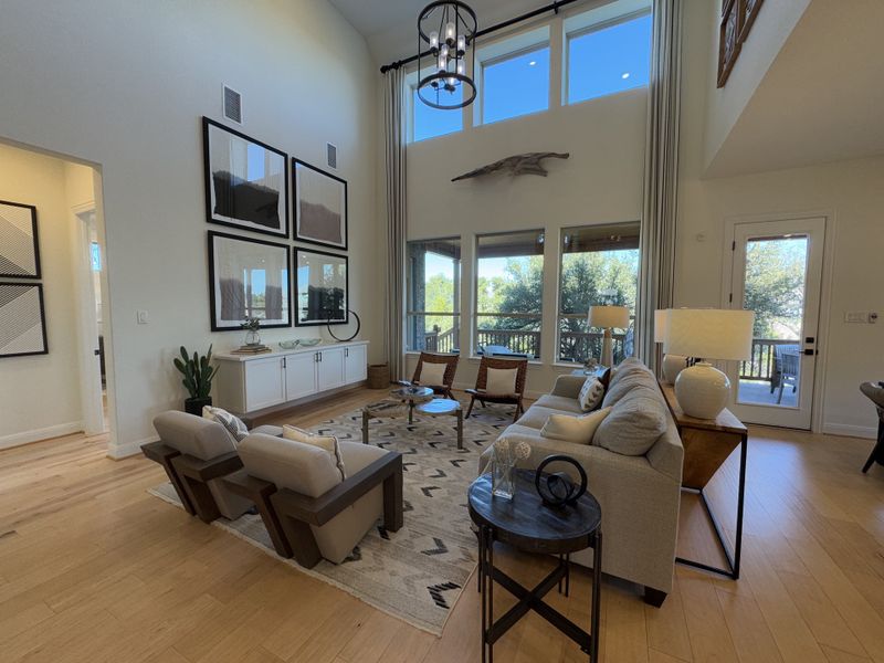A spacious living room with high ceilings, large windows, and contemporary decor. A spacious living room with high ceilings, large windows, and contemporary decor.