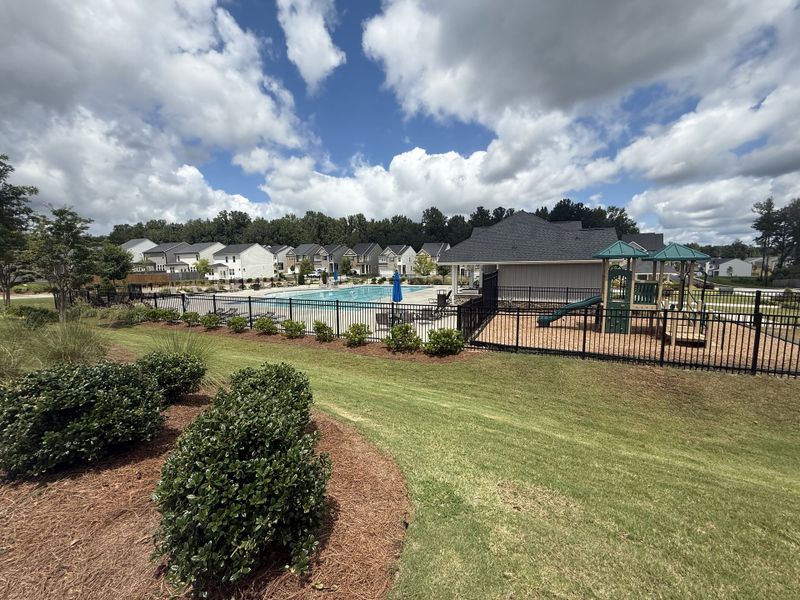 A community playground and pool area with lush landscaping in Poplar Preserve by D.R. Horton (Newnan, GA).